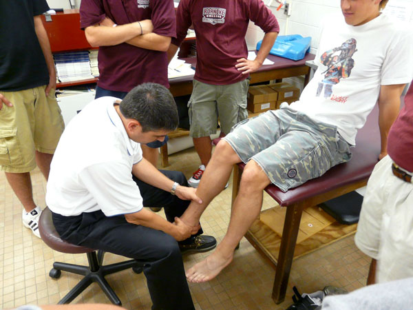 Performing an exam and teaching at Roanoke College dr delmas bolin in roanoke virginia working on ankle injury in his sports medicine practice